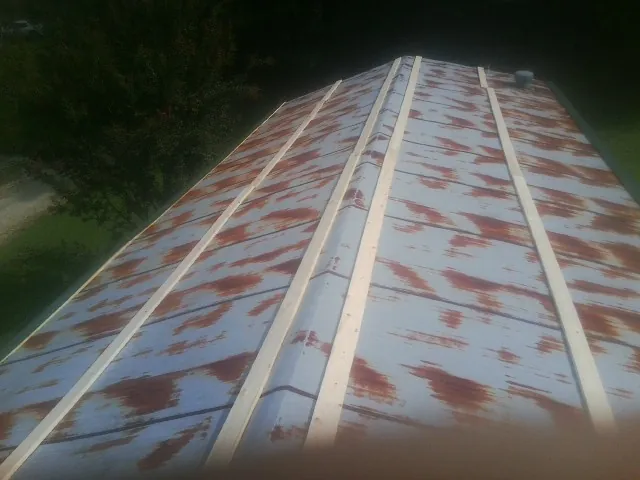 Rusted metal roof panels with new wood purlins before replacement — Storm Damage Roof Repair in Tribune by Roofing Brothers